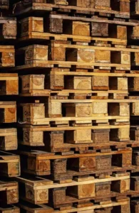A large stack of heat-treated pallets is arranged in an orderly, vertical formation.
